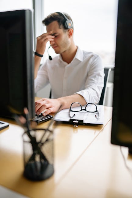 tired office worker rubbing eyes while looking at computer screen showing digital eye strain